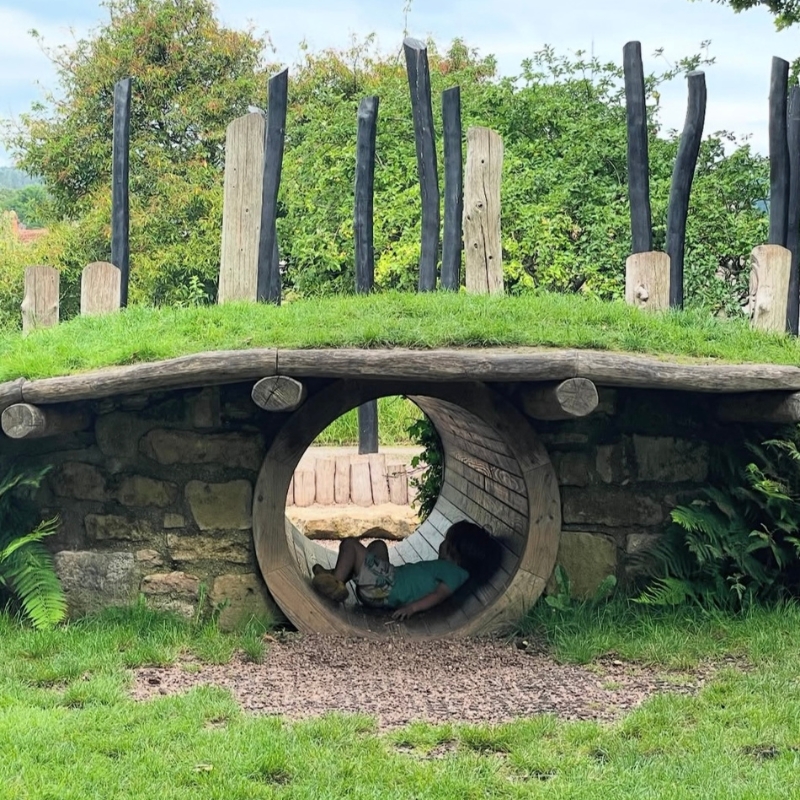 An image of a child playing in the Dragon's Lair play area at The Bishop's Palace in Wells, Somerset.