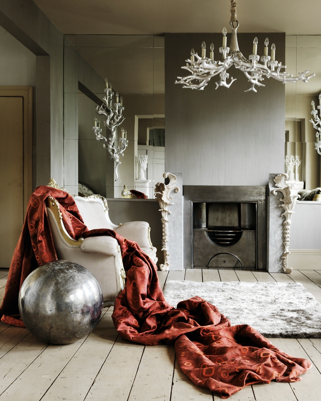 An image of red fabric on a white sofa with a glitter ball in front.