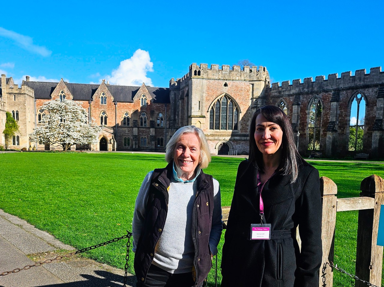 Image of two ladies in front of a historic building with lawns behind them